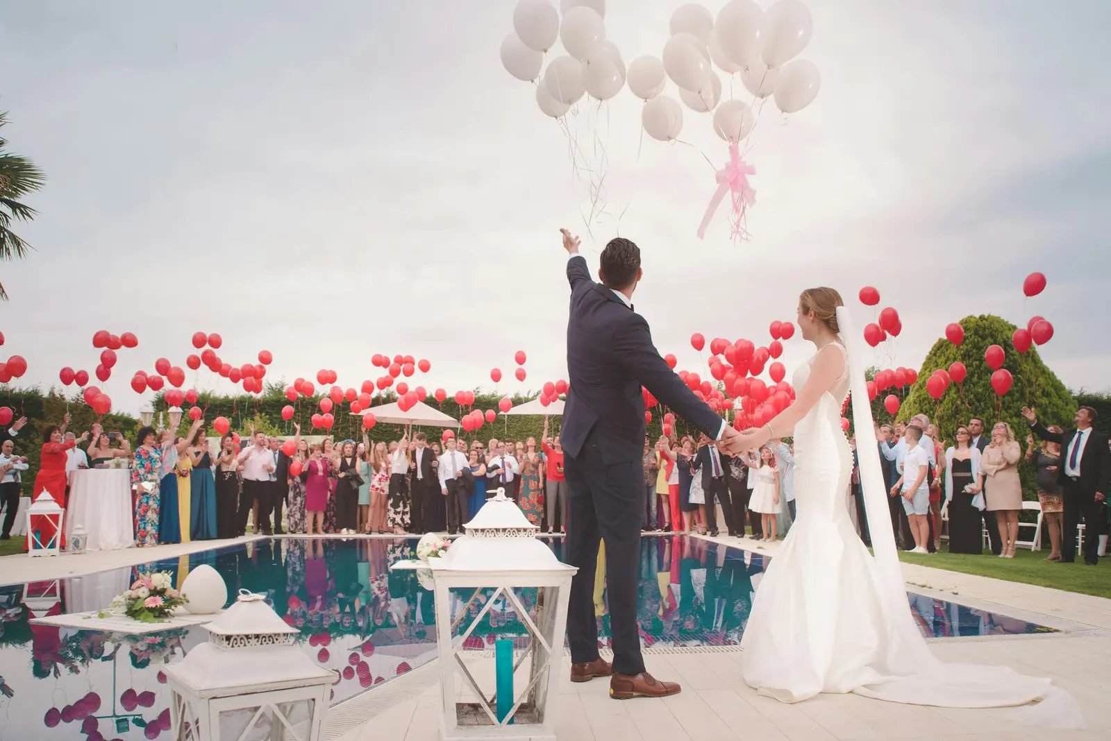 Boda al aire libre junto a una alberca decorada con globos