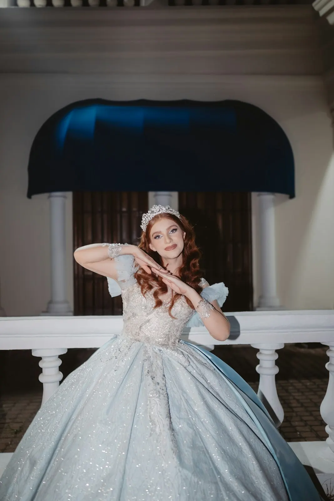 Quinceañera con vestido azul brillante y tiara