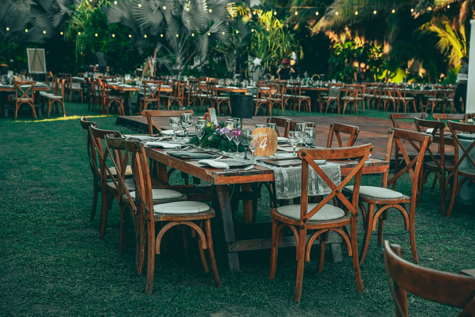 Jardín tropical con mesas largas montadas para recepción